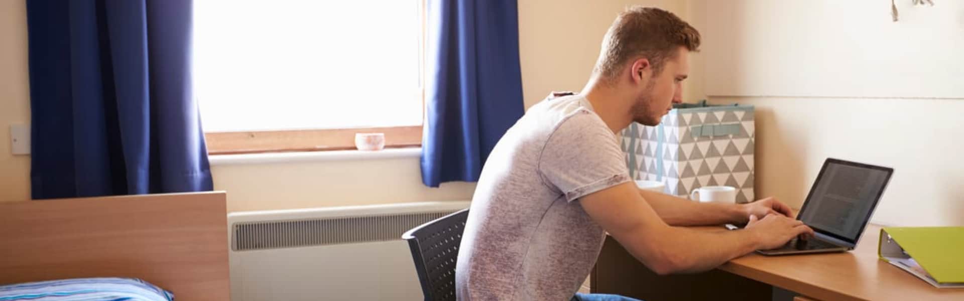 Student using a laptop in their room