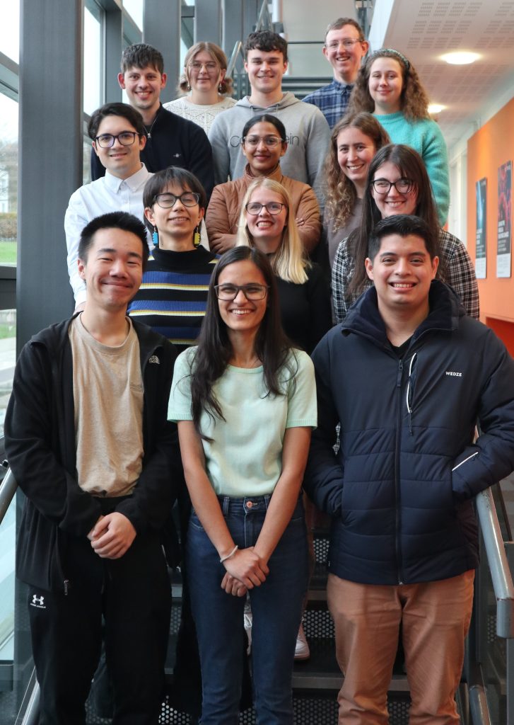 STOR-i MRes students stood on stairs smiling.