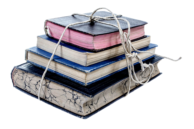 Four books, piled upon one another in ascending size, tied in a bundle with string